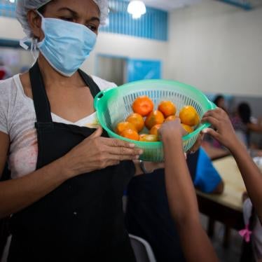 A girl reaches for a tangerine at a soup kitchen in Petare, Venezuela, February 27, 2020. 