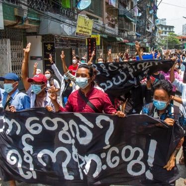 Anti-coup protesters hold a banner that reads "What are these? We are Yangon residents!" as they march during a demonstration in Yangon, Myanmar on Tuesday April 27, 2021.