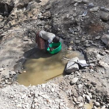 A 9-year old girl collects sand at a mining site in Uganda. 
