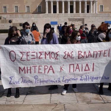 Protesters in Athens, Greece on March 27, 2021 stand outside the Greek Parliament displaying a banner that reads “your sexism is harming both mother and child” against a new law that introduces presumptive co-custody of children, even in cases of domestic violence.