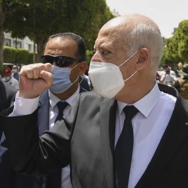 Tunisian President Kais Saied raises his fist to bystanders as he walks along the avenue Bourguiba in Tunis, Tunisia, August 1, 2021.