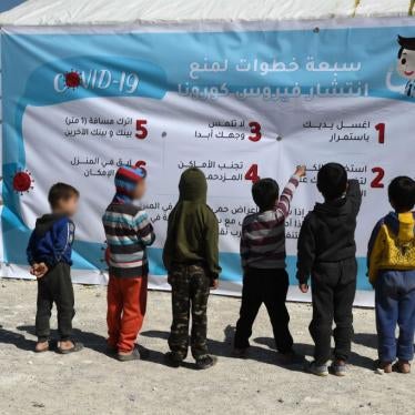 Displaced Syrian children read a poster, outlining 7 steps to prevent the spread of COVID-19 coronavirus disease, at a camp for the internally displaced near Dayr Ballut, near the Turkish border in the rebel-held part of Aleppo province on March 22, 2020, during a campaign to prevent the spread of the virus.
