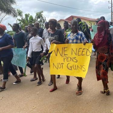 A group of protesters holding signs that say "We Need Pens, Not Guns"