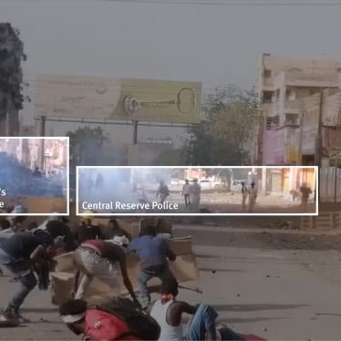 A screenshot from the video posted on Facebook. In the foreground protesters are using cardboard sheets as shields. In the background, a four-wheel armored vehicle is on the left with approximately 10 CRP officers in khaki camouflage standing nearby.