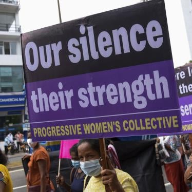A protester holds a sign that reads "Our Silence, Our Strength"