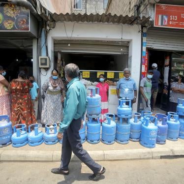 Sri Lankans wearing facemasks wait in line with their empty gas cylinders near a gas shop at Colombo, Sri Lanka, April 1, 2022.