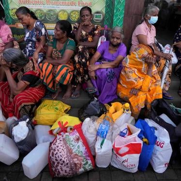 Women wait near an empty fuel station