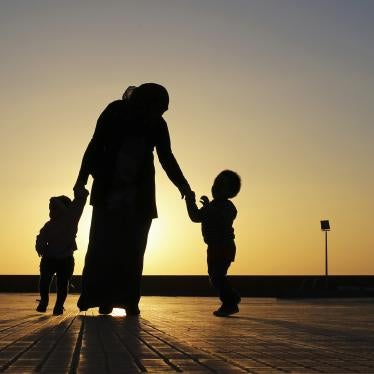 A woman walks with her two children at sunset near the seashore in Benghazi.