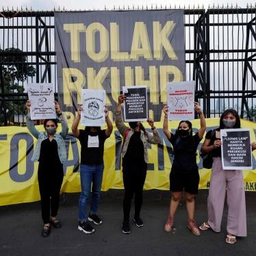 Protesters hold up signs outside parliament in Jakarta