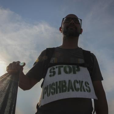 A man holds a banner during a protest against the violent pushbacks of migrants, allegedly conducted by Croatian police, near the border crossing between Croatia and Bosnia and Herzegovina