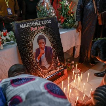 Mourners place candles in a room of Radio Amplitude FM where a portrait of journalist Martinez Zogo has been placed to pay tribute to him in Elig Essono district in Yaounde, Cameroon, on January 23, 2023. © DANIEL BELOUMOU OLOMO/AFP via Getty Images