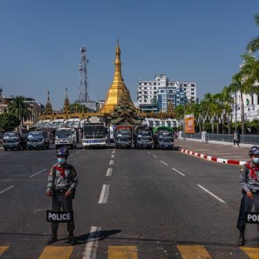 Police block a road leading to City Hall as protesters approach on February 13, 2021, in Yangon, Myanmar. 