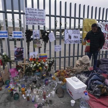 An altar with candles and photos covers the fence outside a Mexican immigration detention center