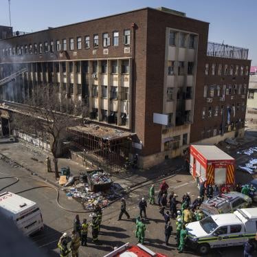 Medics stand by a burning apartment block in Johannesburg on August 31, 2023.