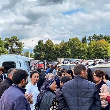 A local government worker, right in red, tries to reassure residents during shooting in the vicinity, in Stepanakert/Khankendi, Nagorno-Karabakh on September 21, 2023. 