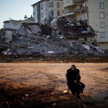 A woman waits beside a building that collapsed in the February 6 earthquakes that devastated provinces of southern Türkiye and killed over 50,000 people, injuring and displacing hundreds of thousands more.  Pazarcık, Kahramanmaraş province, February 13, 2023. 
