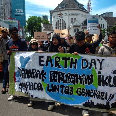 Protesters march with a banner for Earth Day