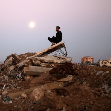 The moon rises as a man sits atop a pile of rubble it al-Bureij refugee camp in central Gaza Strip on November 15, 2024, amid ongoing hostilities in Gaza.