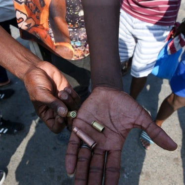 People hold pistol and rifle bullet cartridges fired by police 