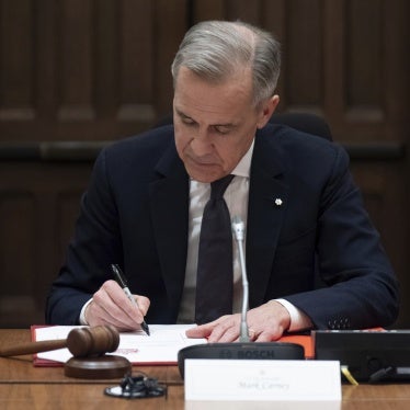 Canadian Prime Minister Mark Carney signs a document during cabinet meeting on Parliament Hill in Ottawa., March 14, 2025.