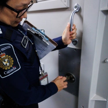 An officer demonstrates locking the door of a wet cell at the Toronto Immigration Holding Centre