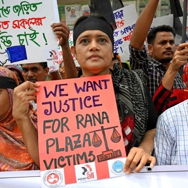 People hold protest signs that read "We want justice for Rana Plaza victims"