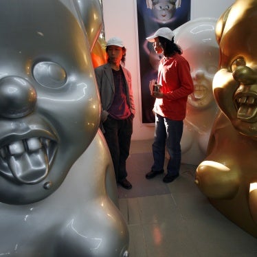 Chinese artists the Gao Brothers, Zhen and Qiang, with some of their "Miss Mao" pieces that feature life-sized, Pinocchio-nosed sculptures of Mao Zedong in their studio in Beijing, October 16, 2007.