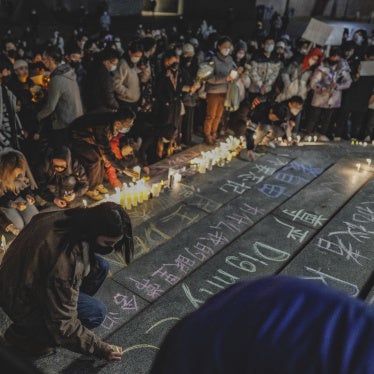 A protester writes "dignity" in English and Chinese in a show of solidarity with the White Paper protest in China at the University of Washington in Seattle, December 4, 2022.