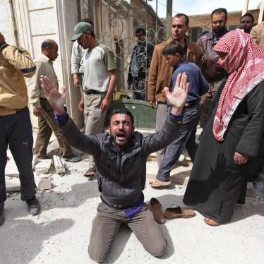 A man is overcome with grief in front of a destroyed mosque in Taftanaz where local residents gathered those killed after government forces attacked the town on April 3 and 4. 