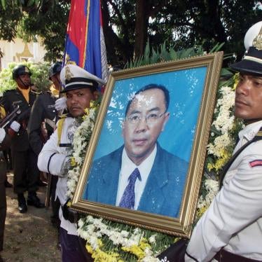 Cambodian police carry a portrait of murdered opposition party official Om Radsady at his funeral ceremony in Phnom Penh on February 21, 2003.
