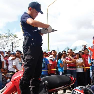 Police officers at the crime scene of the murder of Rogelio Butalid, a broadcast commentator, outside his radio station in Tagum City, in the southern Philippines on December 11, 2013.