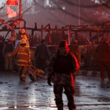 Afghan policemen and fire-fighters inspect the wreckage of a minibus in Kabul targeted in a suicide attack that killed seven journalists affiliated with Tolo TV, January 20, 2016. 