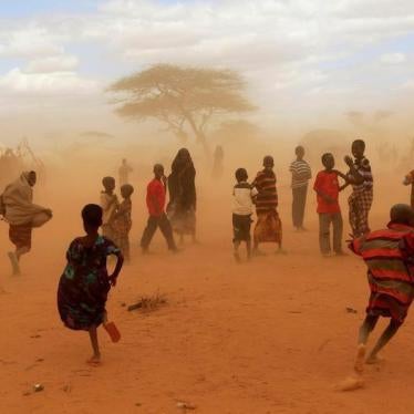 Newly-arrived refugees run away from a cloud of dust at the Dagahaley refugee camp in Dadaab, near Kenya's border with Somalia in Garissa County, Kenya, July 16, 2011.