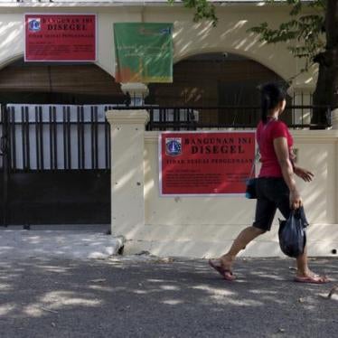A woman walks by an Ahmadiyah mosque that was closed by government authorities in South Jakarta, Indonesia.