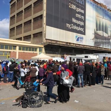 Asylum seekers and migrants at a makeshift camp at the port of Piraeus, queuing for distribution of survival kits by the Hellenic Red Cross. In the absence of any visible government support or personnel the day to day operation of the camp is dependent on