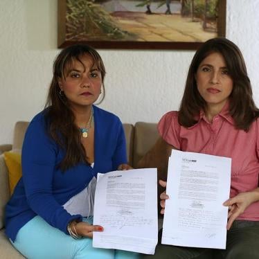 Two public sector employees who supported the recall referendum display letters firing them from their jobs in Venezuela on June 27, 2016. 