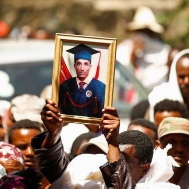 A man at a funeral holds up the portrait of Tesfu Tadese Biru, 32, a construction engineer who died during a stampede after police fired warning shots at an anti-government protest in Bishoftu during Irreecha, the thanksgiving festival of the Oromo people