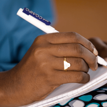 A picture of a hand writing on notepad.