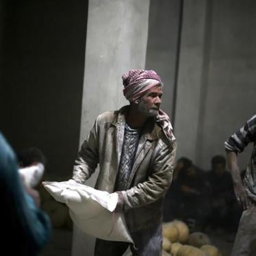 Men store bags of flour unloaded from a Red Crescent aid convoy in the rebel-held, besieged town of Jesreen in Eastern Ghouta, Syria on March 7, 2016. 