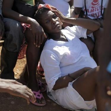 A pregnant woman rests on the floor while attending a Sunday mass on the outskirts of Anse-a-Pitres, Haiti