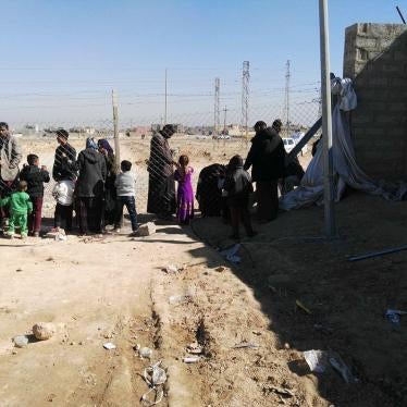 Residents of Shahama camp speak with relatives through the camp fence. 
