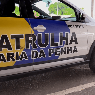 A close-up of a Brazilian police car with the words "Patrulha Maria da Pena" on its side.