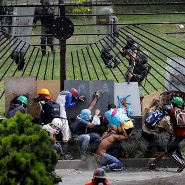 Demonstrators clash with riot security forces at the fence of an air base while rallying against Venezuela's President Nicolas Maduro in Caracas, Venezuela.