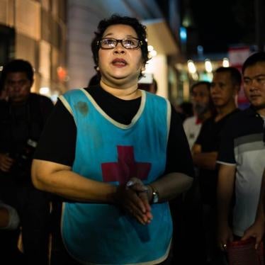 On August 30, 2017, Phayao Akhard wears the bloody nurses gown worn by her daughter, nurse Kamolkate “Kate” Akhard, when she was killed by Thai Special Forces soldiers while tending wounded persons at the front of Wat Pathum temple on May 19, 2010.