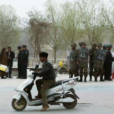 201712asia_china_xinjiang2 Police officers check the identity cards of a people as security forces keep watch in a street in Kashgar, Xinjiang Uyghur Autonomous Region, China on March 24, 2017.