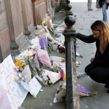A woman lays flowers for the victims of the Manchester Arena attack, in central Manchester, Britain May 23, 2017. REUTERS/Darren Staples
