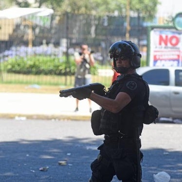 A member of Argentine National Gendarmerie aims his gun to demonstrators during a protest.