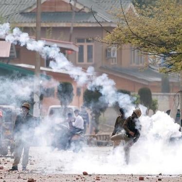An Indian police officer throws a tear smoke shell toward students during a protest against recent killings in Kashmir, April 5, 2018.