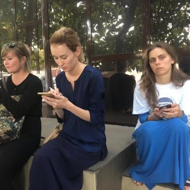 Journalists and human rights defends wait on the doorstep of a Chechnyan court building after the judge closed the hearings for human rights defender Oyub Titiev to the public.