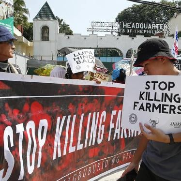 Protesters display placards during a rally outside a police and a military camp to protest the weekend killings of nine farmers in Sagay city